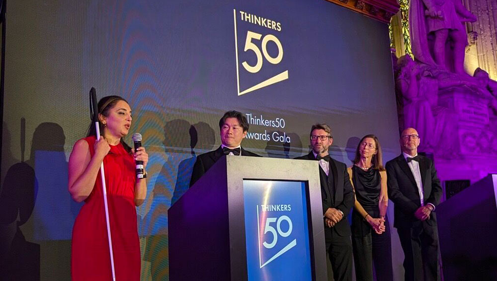 Sheena Iyengar (left) speaks on stage having received the Thinkers50 Innovation Award, presented by Fujitsu’s Ichiro Aoyagi (second left).