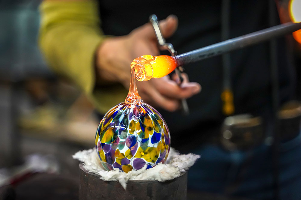 Shaping molten glass into a piece of art